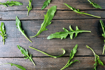 Green arugula leaves on wooden table
