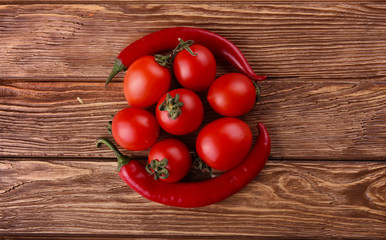 Red hot cherry and chili peppers over white wooden background