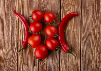 Red hot cherry and chili peppers over white wooden background