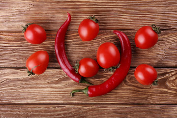 Red hot cherry and chili peppers over white wooden background