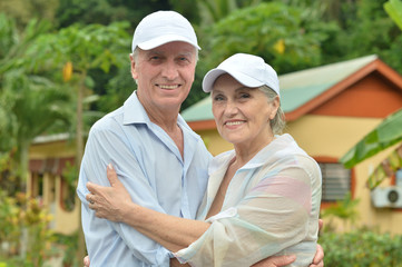 Elderly couple standing embracing outdoors