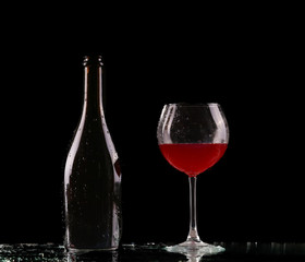Naklejka na ściany i meble Glass and bottle of red wine splash on black