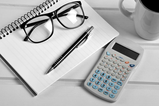 Notebook pen eyeglasses and calculator