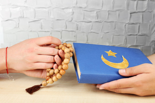 Hands of two friends with different religions symbols