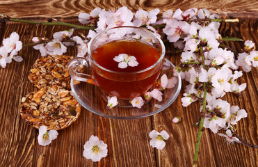 tea and a branch of cherry blossoms on a wooden