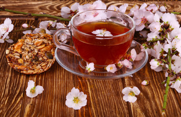 Obraz na płótnie Canvas tea and a branch of cherry blossoms on a wooden
