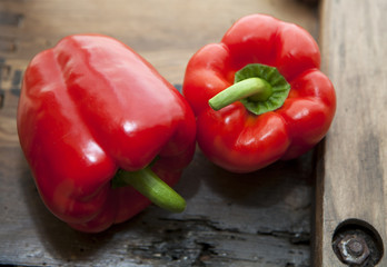 deux poivrons rouge sur fond de bois ancien