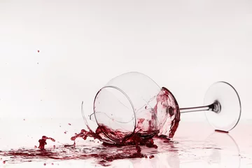 Fotobehang Alcohol Gebroken wijnglas op tafel. Rode wijn ingeschonken, als bloed.