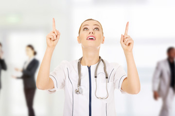 Medical doctor woman pointing up.