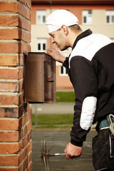 Chimney sweep man checking brick chimney