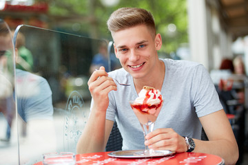 Young man with a cup of ice cream in summer