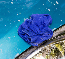Blue car wash cloths on the hood of a blue car.