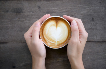 woman hands holding Latte art, coffee cup
