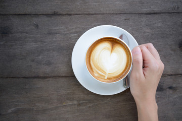 woman hands holding Latte art, coffee cup