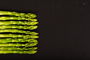 Grüner Spargel auf einer Schieferplatte.