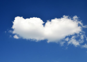 Fototapeta na wymiar Single white cloud in blue summer sky photo