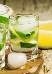 Glass of water with fresh lemon, ice and mint, selective focus