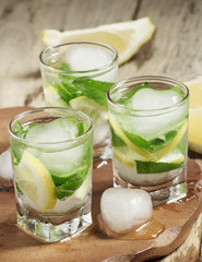 Glass of water with fresh lemon, ice and mint, selective focus