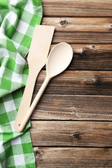 Empty wooden table with wooden spoon and napkin on brown backgro