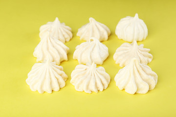 Fototapeta na wymiar French meringue cookies on yellow background