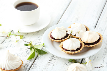 French meringue cookies in tartlet on white wooden background