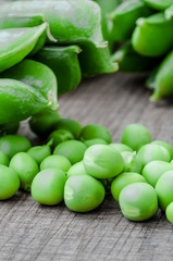 Green organic peas on wooden background, shalow focus