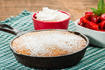Cast iron skillet with cake and berries