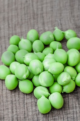 Green organic peas on wooden background, shallow focus