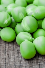 Green organic peas on wooden background, shallow focus