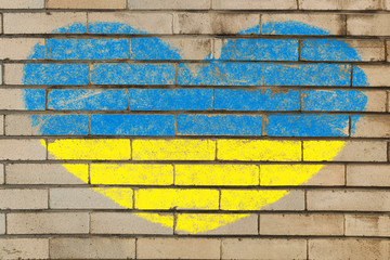 heart shape flag of ukraine on brick wall