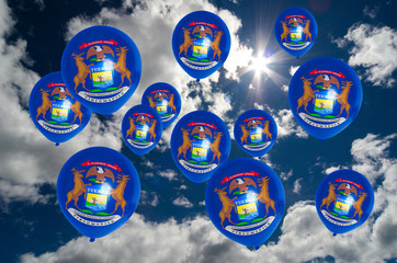 many balloons with michigan flag on sky