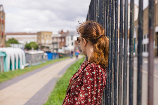 Young woman resting by fence outside