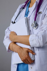 Female doctor standing with a folder , isolated on white