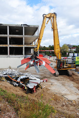 Demolition of a house with yellow construction machine