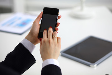 Businesswoman using her phone in office 