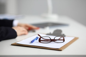 Young woman sitting  at the desk with folder