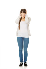 Teen woman covering ears with hands.