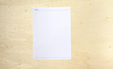 Blank white note sheet on wood background