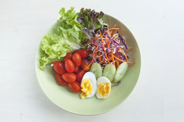 Fresh vegetable salad with egg in green plate 