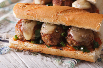 Tasty sandwich with meatballs and sauce close-up