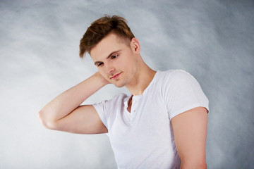 Young man holding his neck in pain.