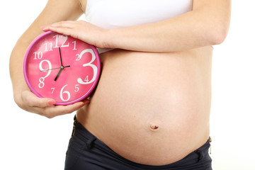 Belly of pregnant woman with clock on white background
