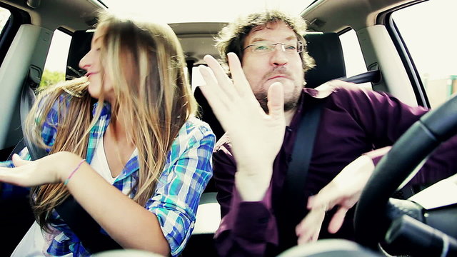 Father and daughter dancing like crazy driving car laughing 