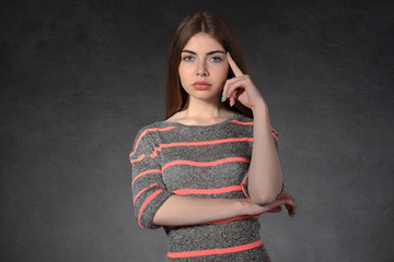 Girl shows pensiveness against a dark background