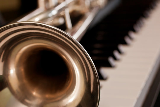 Trumpet segment closeup lying on piano keys