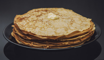 The lot of pancakes on black plate