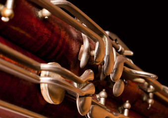Fragment of the bassoon on a black background closeup