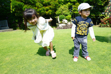庭で遊ぶ笑顔の姉弟