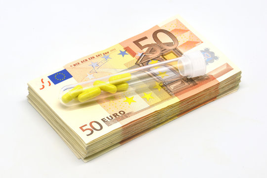 Money pile Euro 50 banknotes with medicine pills