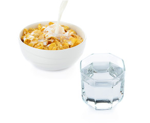 cornflakes in white bowl and drinking water on white